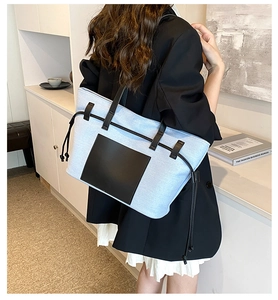 Details von blauem Canvas und schwarzen Ledernähten an einer großen, modischen Tote Bag