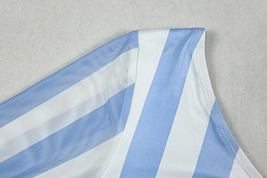 Detail von blau-weiß gestreiftem Stoff mit halbtransparentem Mesh-Einsatz und feiner Naht