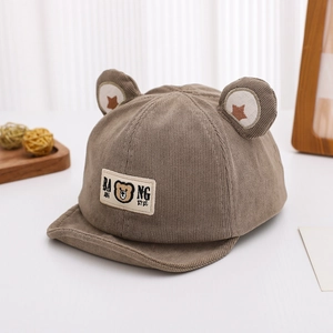 Détail du bonnet bébé en velours côtelé marron avec oreilles à étoiles et broderie