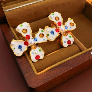 Detailed macro view of vintage flower earrings with colorful rhinestones and pearls