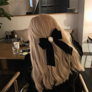 Detail of a black velvet ribbon hair clip with vintage embossed cameo on blond hair