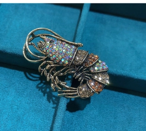 Detailed macro shot of vintage bronze lobster brooch with sparkling colorful rhinestones