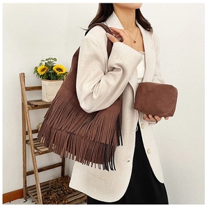 Detail of dark brown faux suede tote bag with fringe tassels and small matching pouch