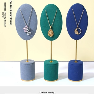 Detailed set of velvet necklace stands with gold metal rods and round marble-style bases