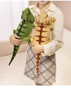 Detailed plush bearded dragon toy with lifelike scale patterns held by a model