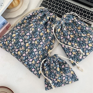 Detail of three floral drawstring storage bags in various sizes for travel and makeup