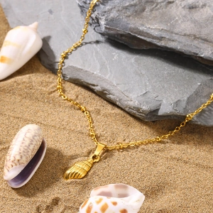 Detail of golden shell pendant necklace on sandy beach with starfish and sea shells