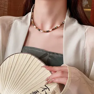 New Chinese vintage beaded necklace with green stone and gold accents on a model