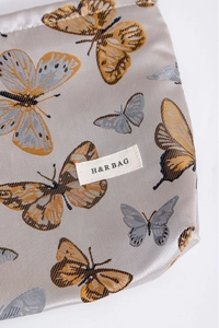 Close-up of butterfly jacquard fabric detail and woven brand label on makeup pouch