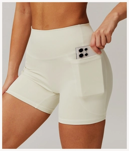 Macro detail of high-waist yoga shorts showing the side pocket holding a smartphone