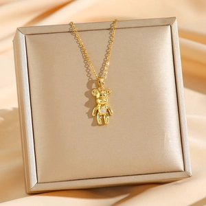 Collana con orsetto dorato e pietra lucida su portagioie color champagne