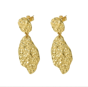 Detailed close-up of gold-plated leaf earrings with irregular hammer texture finish