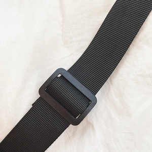 Detail of adjustable black nylon shoulder strap with matte plastic buckle for bags