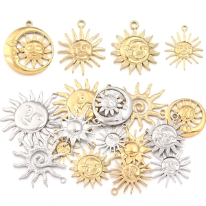 Detailed view of sun and moon face charms in polished gold and silver finish metal