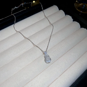 Détail du pendentif gourde en argent avec pierre blanche et bordure en zircons brillants