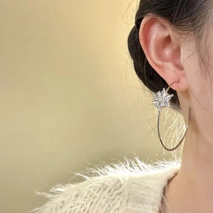 Boucles d'oreilles créoles C avec flocon de neige en argent et zircons sur modèle