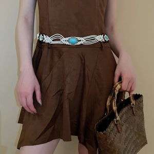 Detail of bohemian white woven belt with turquoise and brown wood beads on a dress