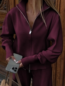 Detailed texture of burgundy knitted fabric with silver zipper and ribbed cuff detail