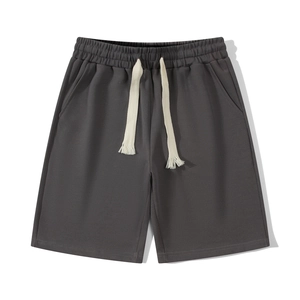 Unisex dark grey waffle knit sweat shorts with off-white drawstring in flat lay view