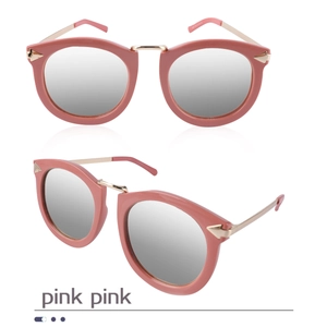Detail of pink cat-eye sunglasses featuring silver mirrored lenses and gold arrow metal accents
