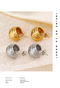 Gros plan de boucles d'oreilles en C géométriques avec texture martelée en or et argent