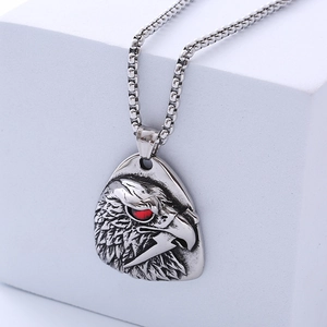 Vintage owl head pendant necklace in antique silver with red stone eyes on stone stand