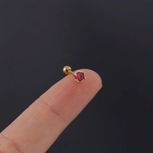 Detailed close-up of a 20G stainless steel stud with a red zircon and screw ball back