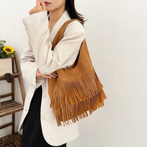 Vintage brown suede shoulder bag with layered fringe design and a bohemian style aesthetic