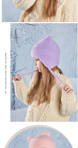 Close-up of soft plush knit texture and cute cat ear design on child winter earflap hat