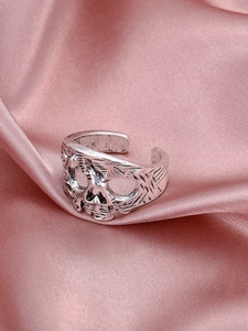 Dettaglio di un anello a teschio vintage stile punk gotico su tessuto di seta rosa