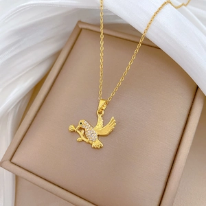 Detailed macro view of a gold swallow necklace with pavé zircon stones on silk