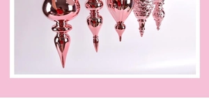 Detail view of five shiny rose gold tapered ornaments for Christmas tree decoration