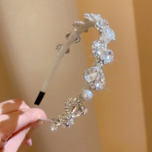 Close-up of elegant silver headband featuring large heart crystals and white pearls