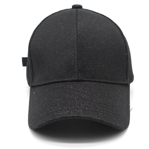 Close-up of a black baseball cap with sparkling sequins and woven metallic fabric texture