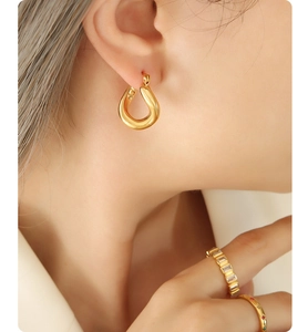 Close-up of 18k gold plated U-shaped earrings with mirror finish and elegant minimalist style