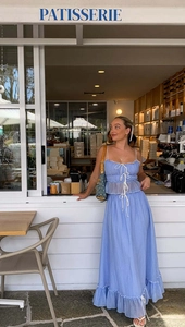 Detail of blue two-piece set featuring ruffled strap top and pleated maxi skirt