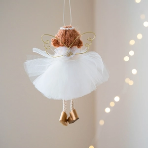 Christmas angel ornament with white mesh skirt and gold wings hanging on grey wall