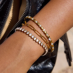 Detailed view of three-piece gold heart zircon and paperclip chain bracelet set