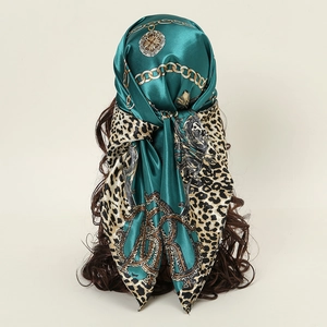 Detail of dark green satin scarf with leopard print and gold chain tied on head