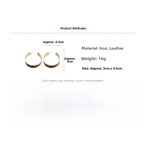 Detail view of oval leopard print leather hoop earrings with golden metal frames and hooks