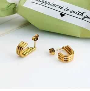 Detail showing the U-shaped golden triple-layered line earrings in titanium steel
