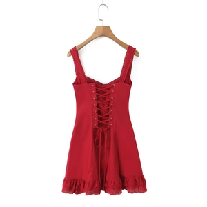 Dettaglio dell'abito rosso in pizzo con lacci sul retro e delicato ricamo traforato
