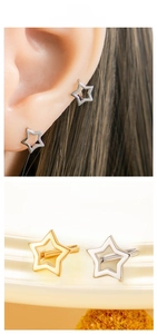 Macro shot of minimalist hollow star-shaped earrings in gold and silver finishes
