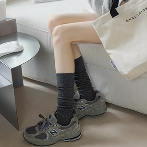 Dark grey slouchy knee-high socks with vertical ribbed texture in minimalist style