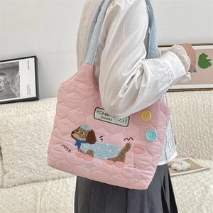 Detalle del bolso tote acolchado rosa con asa azul claro y bordado de perrito