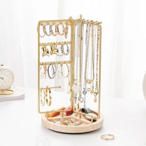 Rotating gold metal jewelry organizer with wooden base and hooks for necklaces and earrings
