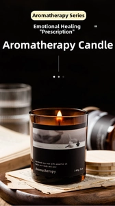 Macro shot of lit soy wax aromatherapy candle in amber glass jar with natural wood lid