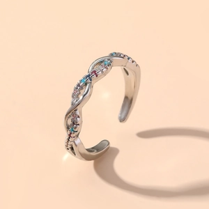 Detail of twisted silver ring with multi-colored crystals and adjustable open band
