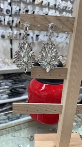 Close-up of elegant oversized rhinestone earrings with silver metal finish and crystals