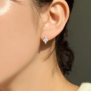 Macro shot of a 925 silver earring featuring a square zircon with halo set stones